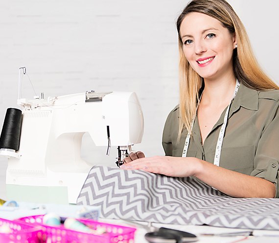Operator sewing conductive textile at an industrial machine