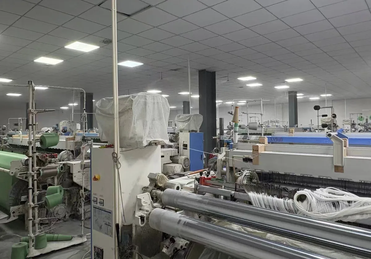 Rapier looms weaving silver-grid fabric at the EarthingTek floor in Minhou, Fujian